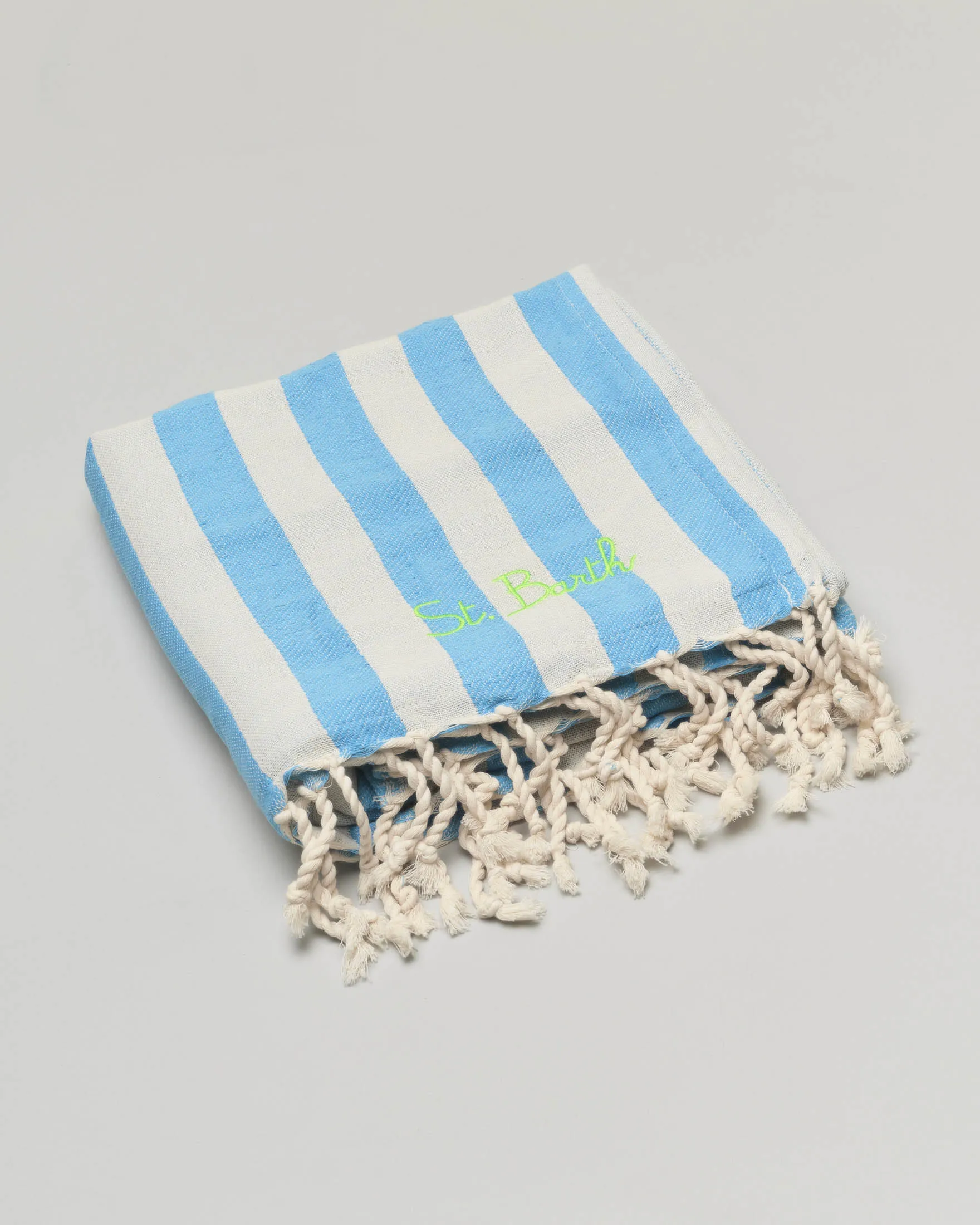 Telo mare in cotone a righe bluette e bianche con frange al fondo e scritta logo ricamata